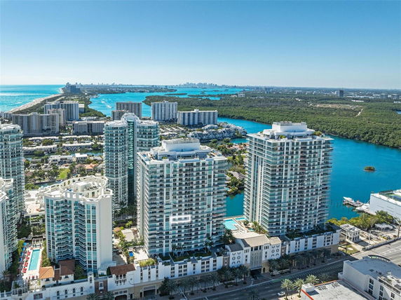 Aerial view of modern high-rise apartment buildings near a body of water.