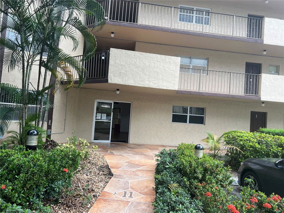 Front view of a multi-story apartment building with balconies.