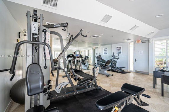Interior view of a gym with exercise equipment including a weight machine and treadmills.