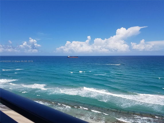 Panoramic view of the ocean with a ship in the distance.