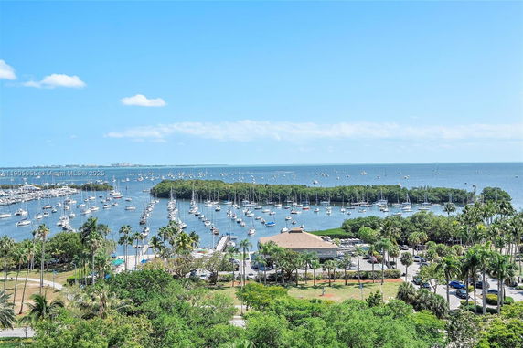 Panoramic view of a marina with numerous boats and the ocean in the background.