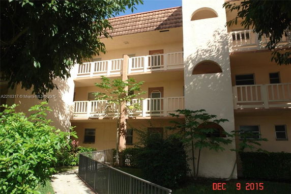 Front view of a three-story building with balconies.