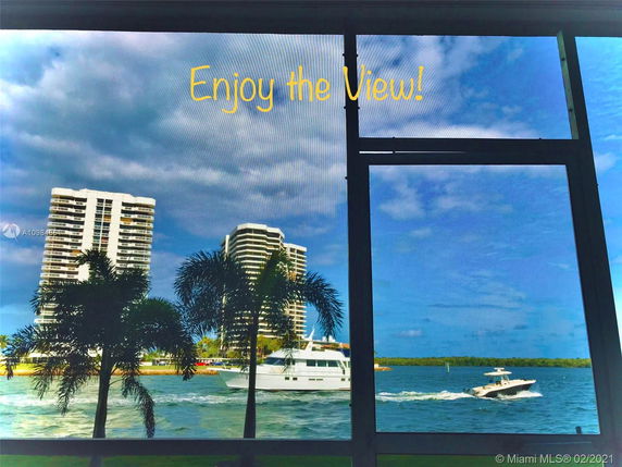 View from inside looking out at tall buildings near water.
