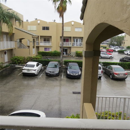 View of a residential parking area in front of a two-story apartment complex.
