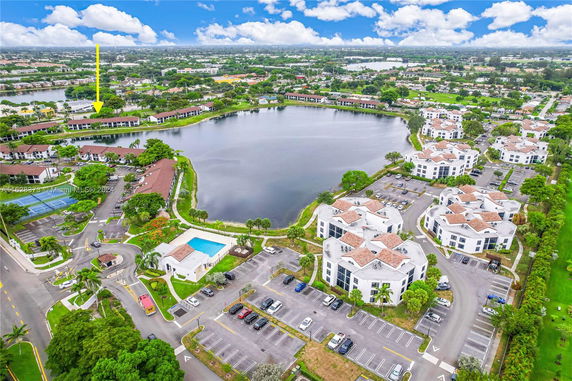 Aerial view of several buildings surrounding a large body of water in a residential area.
