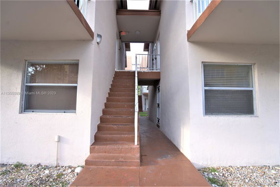 Front view of a building entrance with stairs leading to an upper level.