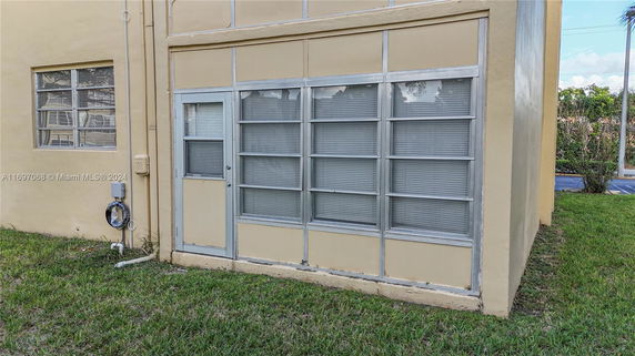 Corner view of a building with large windows and a small entrance door.