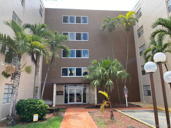 Front view of a multi-story building with a brown exterior and multiple windows.