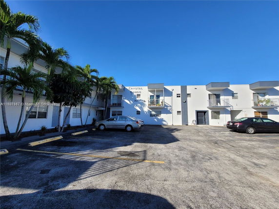 Front view of a two-story condominium building with balconies and parking area.