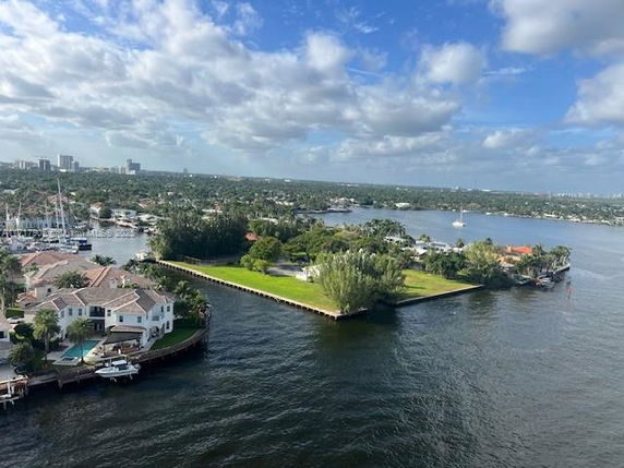 Wide-angle view of water and residential area with houses and greenery.