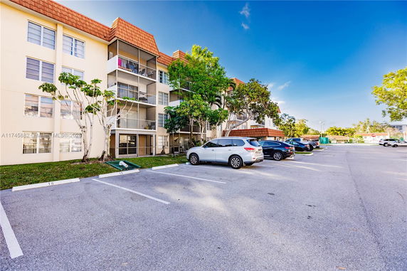 Outdoor parking area in front of a multi-story residential building.