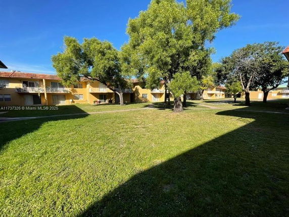 View of surrounding residential buildings with grassy area and trees.
