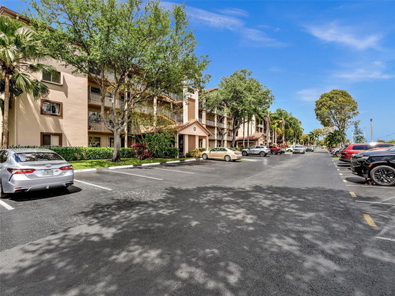Outdoor parking area in front of a multi-story residential building.