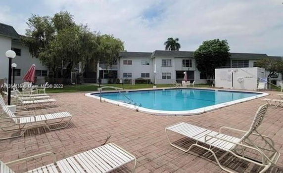 Outdoor area with a swimming pool in the middle of a courtyard.
