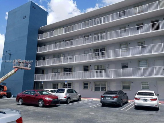 Front view of a multi-story building with balconies on each floor.