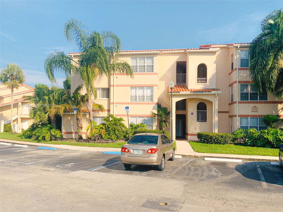 Front view of a multi-story residential building with arched balconies.