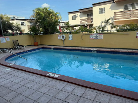 Outdoor swimming pool with surrounding buildings.