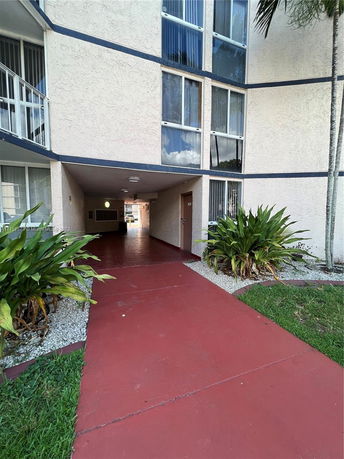 Elevated view of an apartment building entrance with a covered walkway.