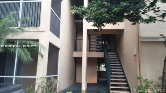 Front view of a building with exterior staircases and screened balconies.