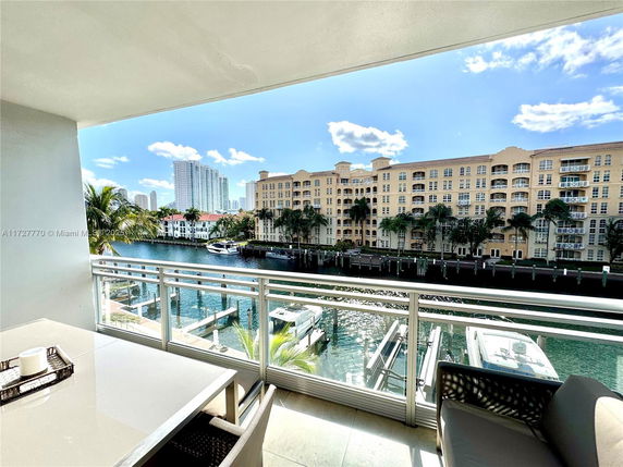 View from a balcony overlooking water and nearby buildings.