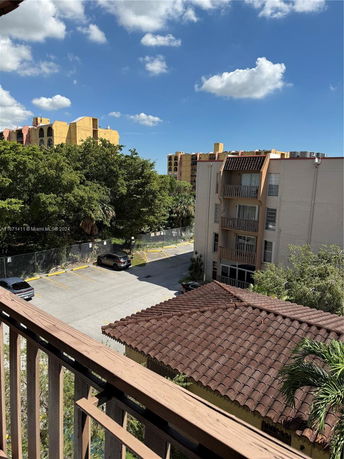 View from a balcony showing multiple residential buildings and trees.