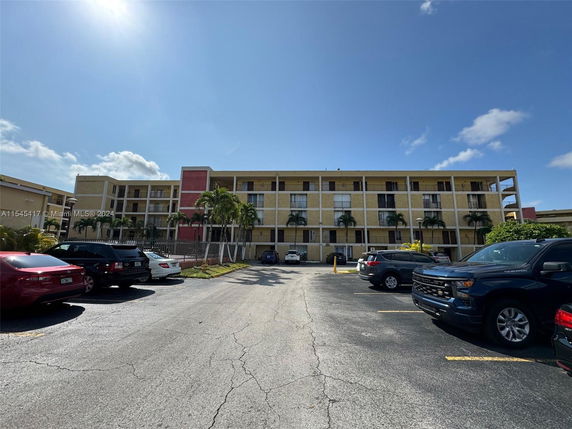 Front view of a multi-story apartment building with balconies.