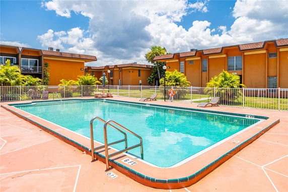 Outdoor swimming pool with surrounding residential buildings.