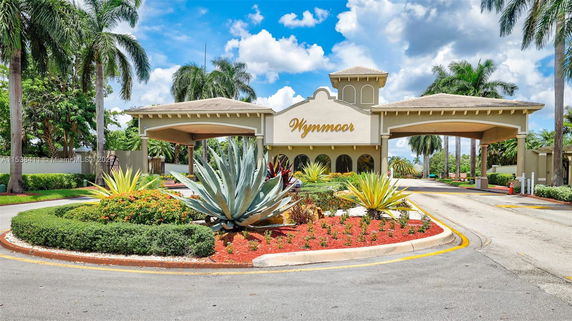 Front view of a building entrance with an archway and landscaped gardens.