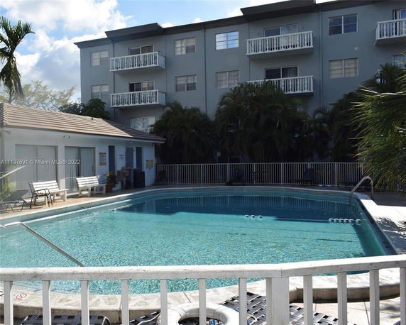 Outdoor swimming pool area with an adjacent building.
