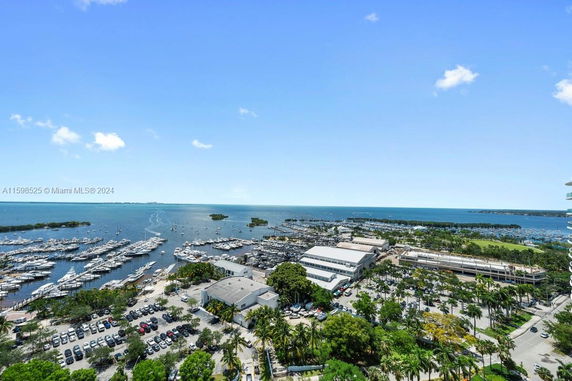 Aerial view of a marina with numerous boats docked along the waterfront.