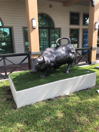 Front view of a building with decorative bull sculpture in the foreground.