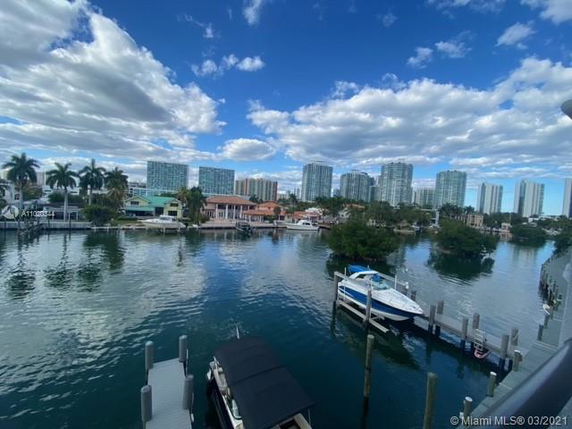 View of a waterfront area with docks and boats, surrounded by mid-rise residential buildings.