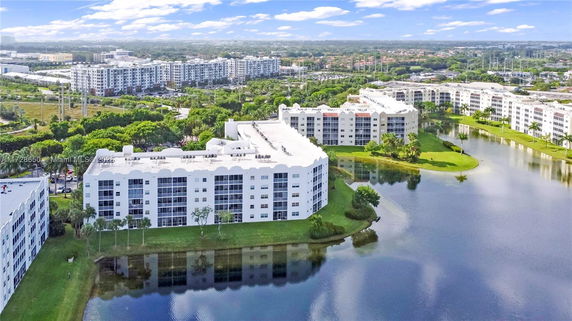 Aerial view of several multi-story residential buildings adjacent to a water body.