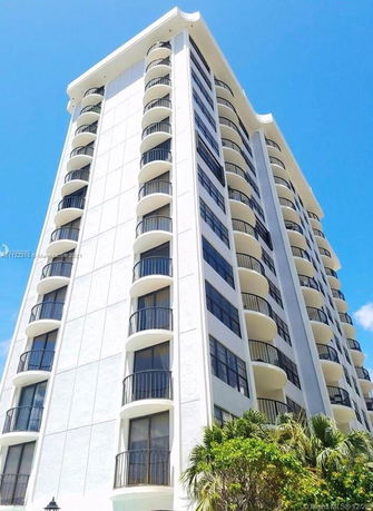 Front view of a multi-story residential building with balconies.