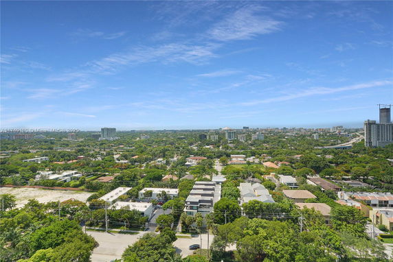 Panoramic view of a cityscape with numerous buildings and greenery.
