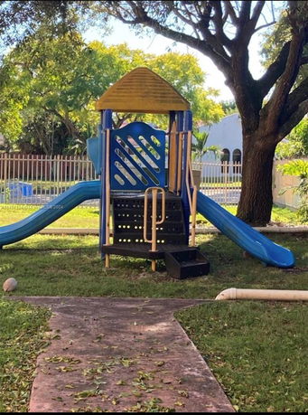 Outdoor playground with a slide and climbing structure.