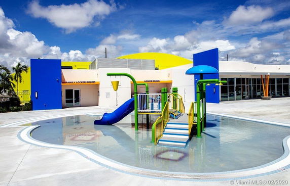 Outdoor play area with colorful water slides and splash features.