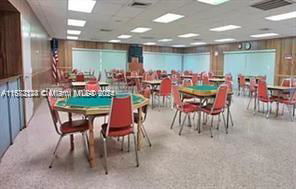 Interior view of a recreation room with tables and chairs for activities.