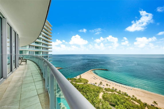 Panoramic view of the ocean from a curved balcony of a high-rise building.