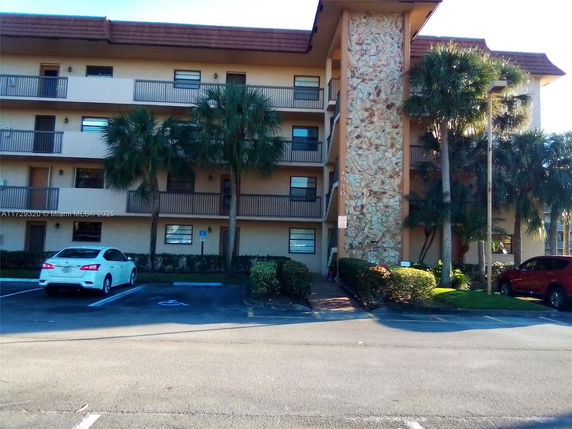 Front view of a multi-story apartment building with a stone facade and balconies.