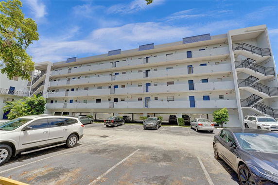 Front view of a multi-story apartment building with external staircases.