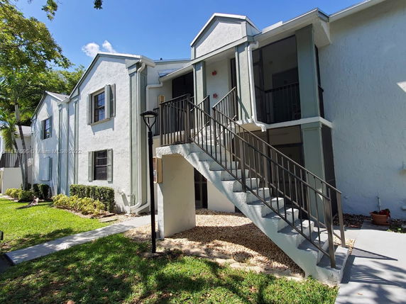 Front view of a two-story residential building with an external staircase.