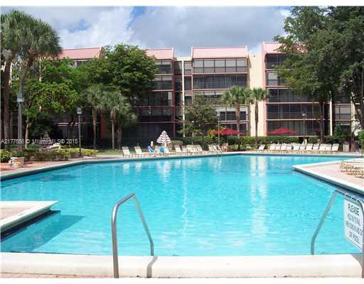 Outdoor swimming pool in front of a multi-story residential building.