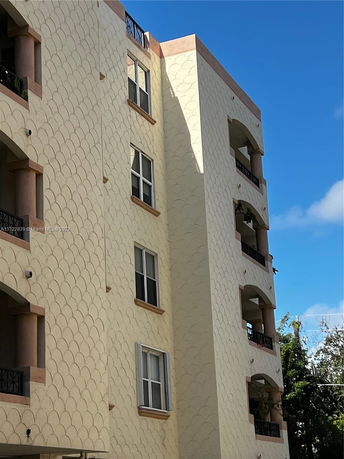 Side view of a multi-story residential building with decorative wall patterns and balconies.