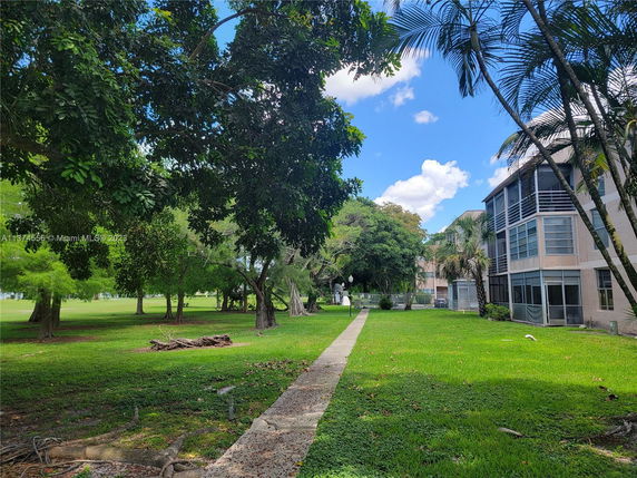 View of a building with a grassy area and trees.