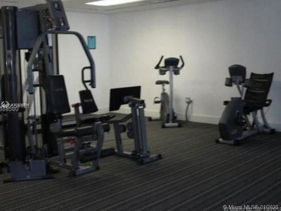 Room with gym equipment including exercise bikes and weight machines.