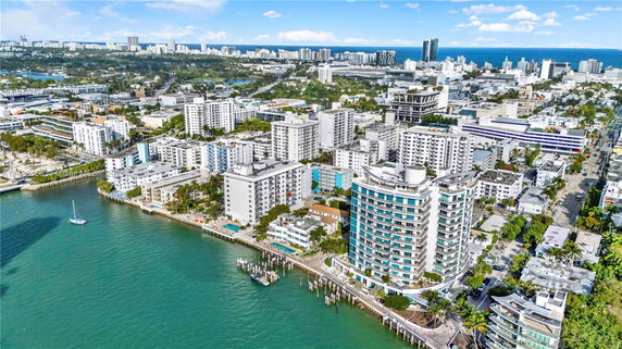 Aerial view of a coastal cityscape with multiple high-rise buildings near the water.