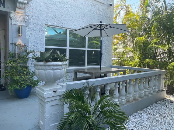 Front view of a house with decorative railing and outdoor seating area.