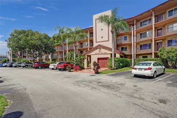 Outdoor parking area in front of a multi-story residential building.
