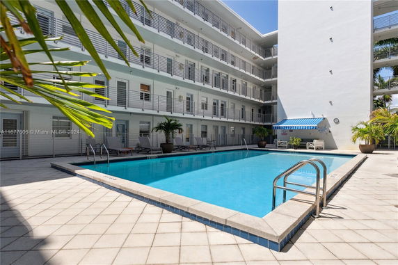 Outdoor swimming pool view with surrounding multi-story building.